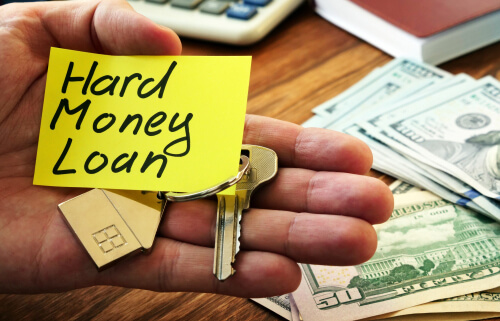 hard money loan written on note in someones hand and they are hodling a house key