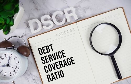 journal with debt service coverage ratio written inside and magnifying glass