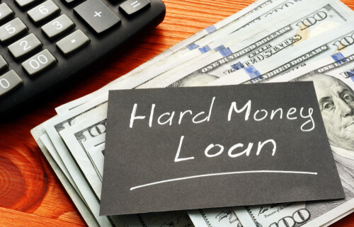 hard money loan written on black paper sitting on top of cash