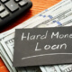 hard money loan written on black paper sitting on top of cash