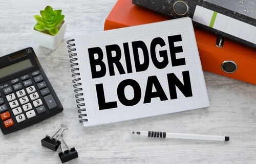 bridge loan written on notepad next to calculator