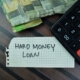 hard money loan written on graph paper tucked under a calculator