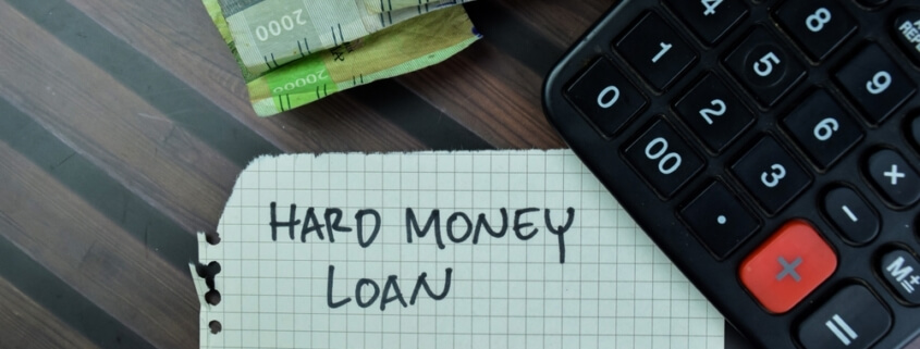 hard money loan written on graph paper tucked under a calculator